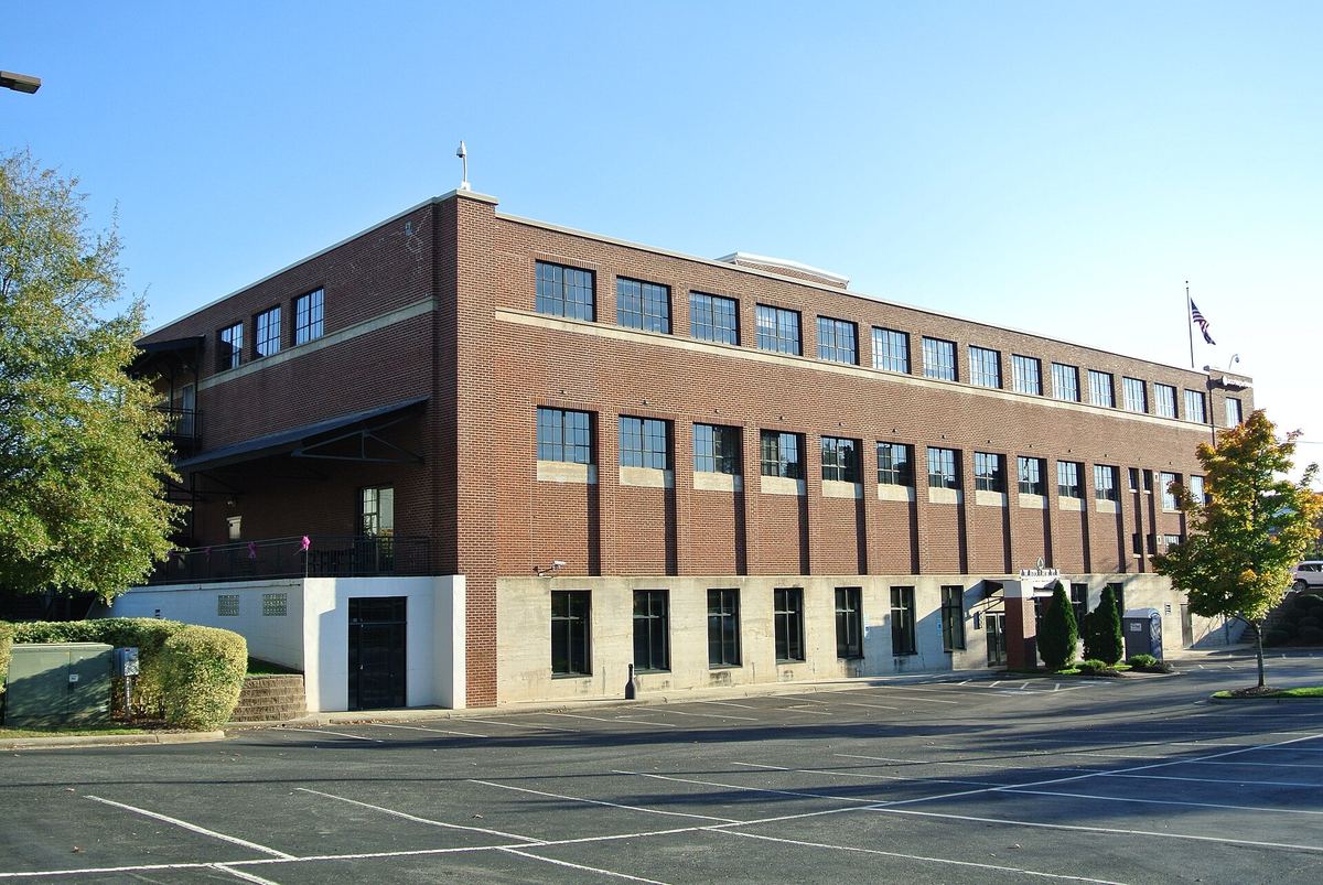 Long three-storey brick and concrete warehouse building running along an empty street, with a plain banded window pattern.
